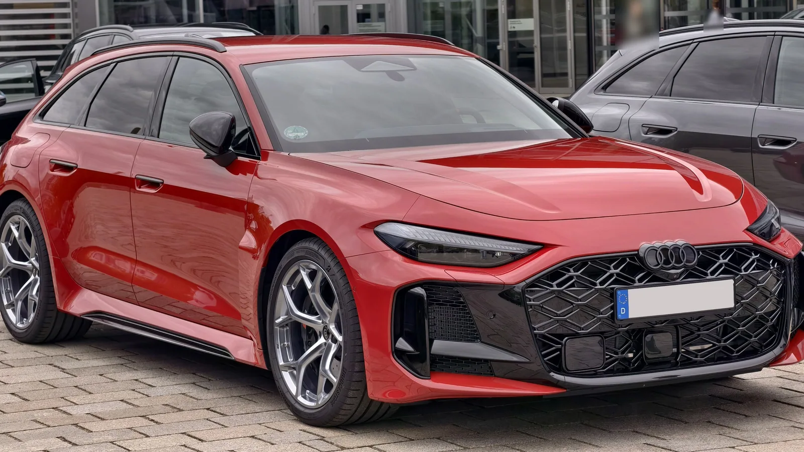 Audi RS 5 Avant rouge de 2026 garée, vue de trois quarts avant