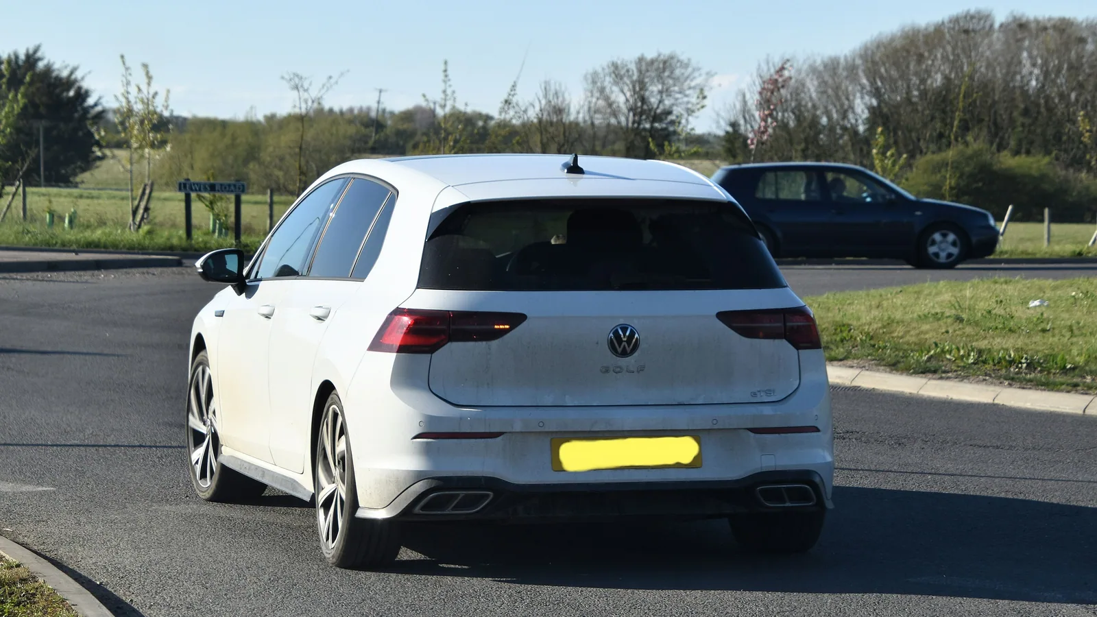 Volkswagen Golf de huitième génération blanche en version 1.5 eTSI, vue de l’arrière sur un parking