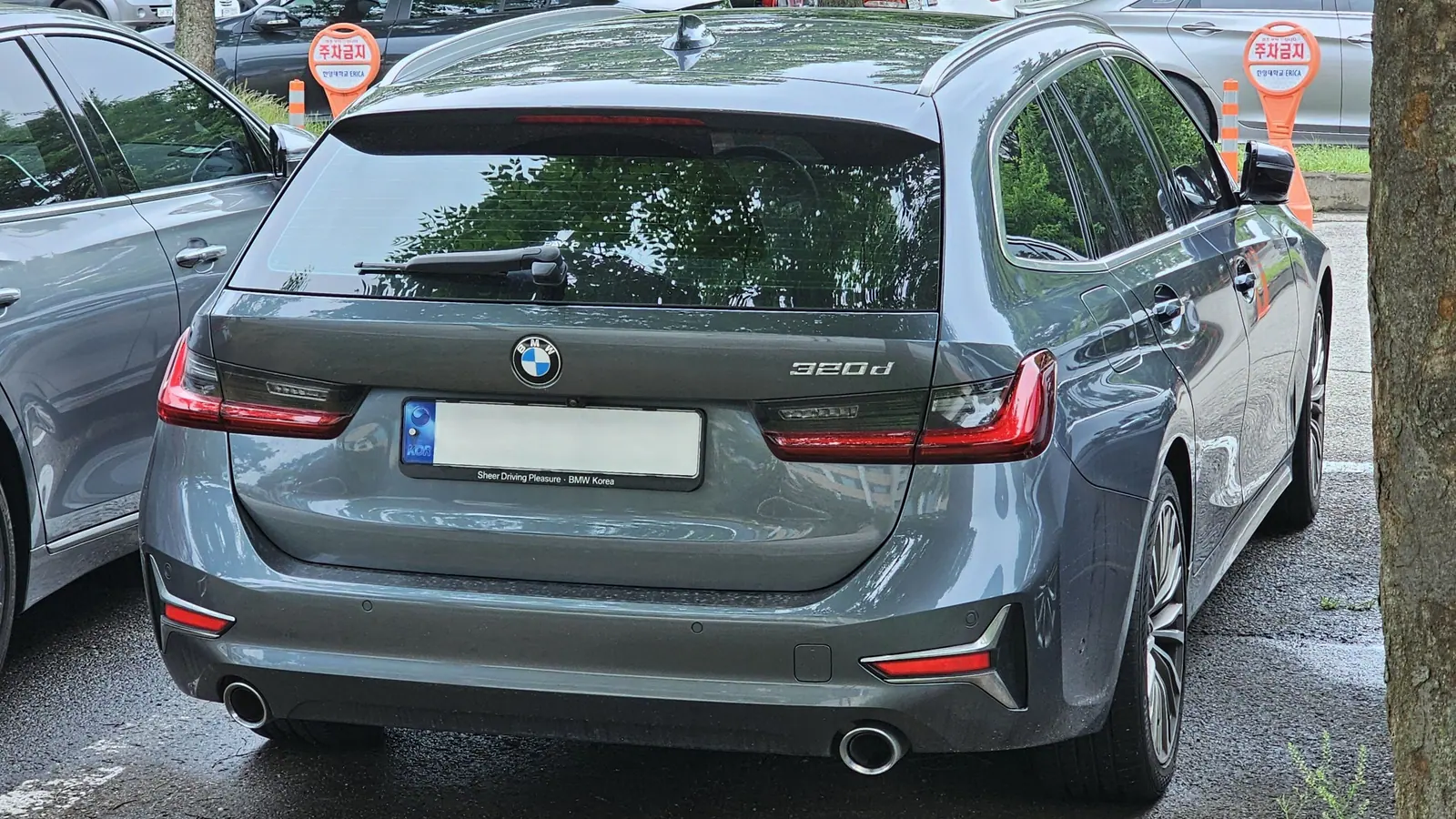 BMW 320d Touring grise vue de trois quarts arrière, le monogramme 320d visible sur le hayon
