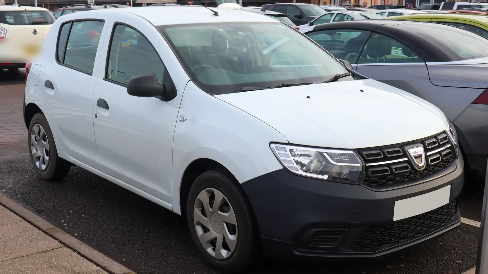 Dacia Sandero blanche de deuxième génération garée sur un parking