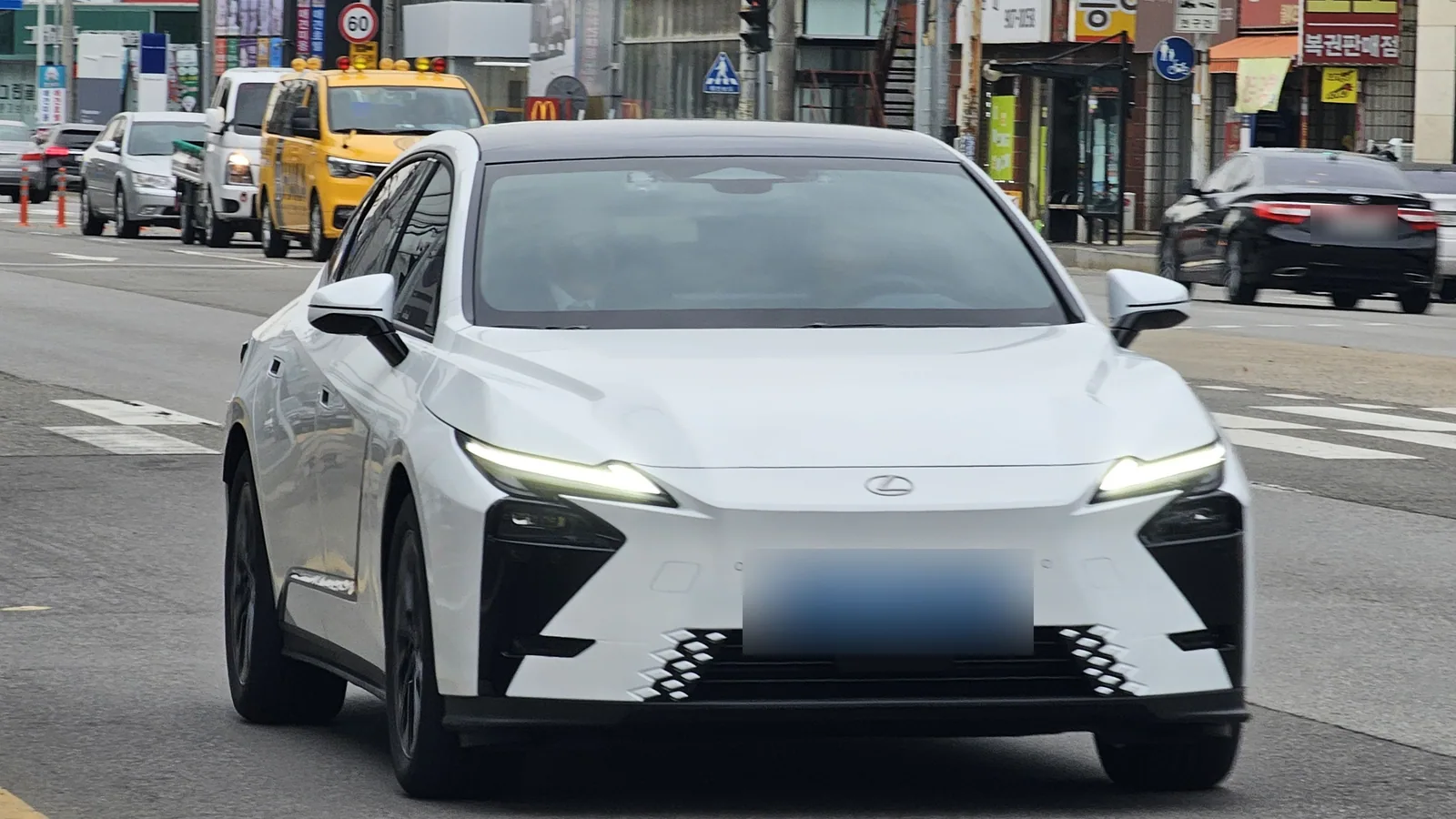 Lexus ES 350e de huitième génération blanche sur la route, vue de trois quarts avant