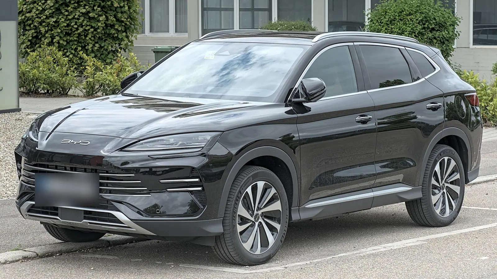 BYD Seal U DM-i noire garée sur un parking, vue de trois quarts avant