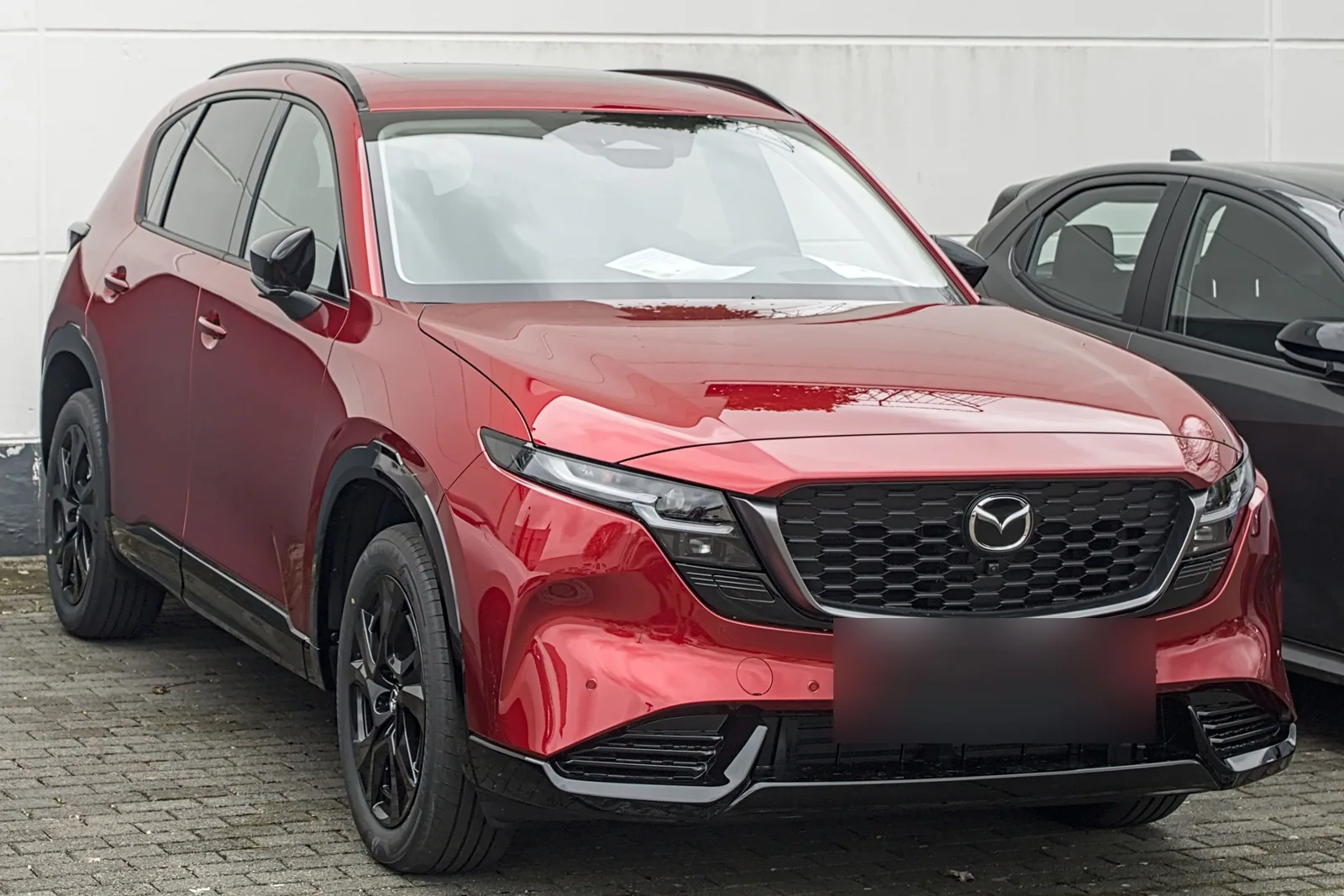 Mazda CX-5 de troisième génération rouge garée dans une rue, vue de trois quarts avant