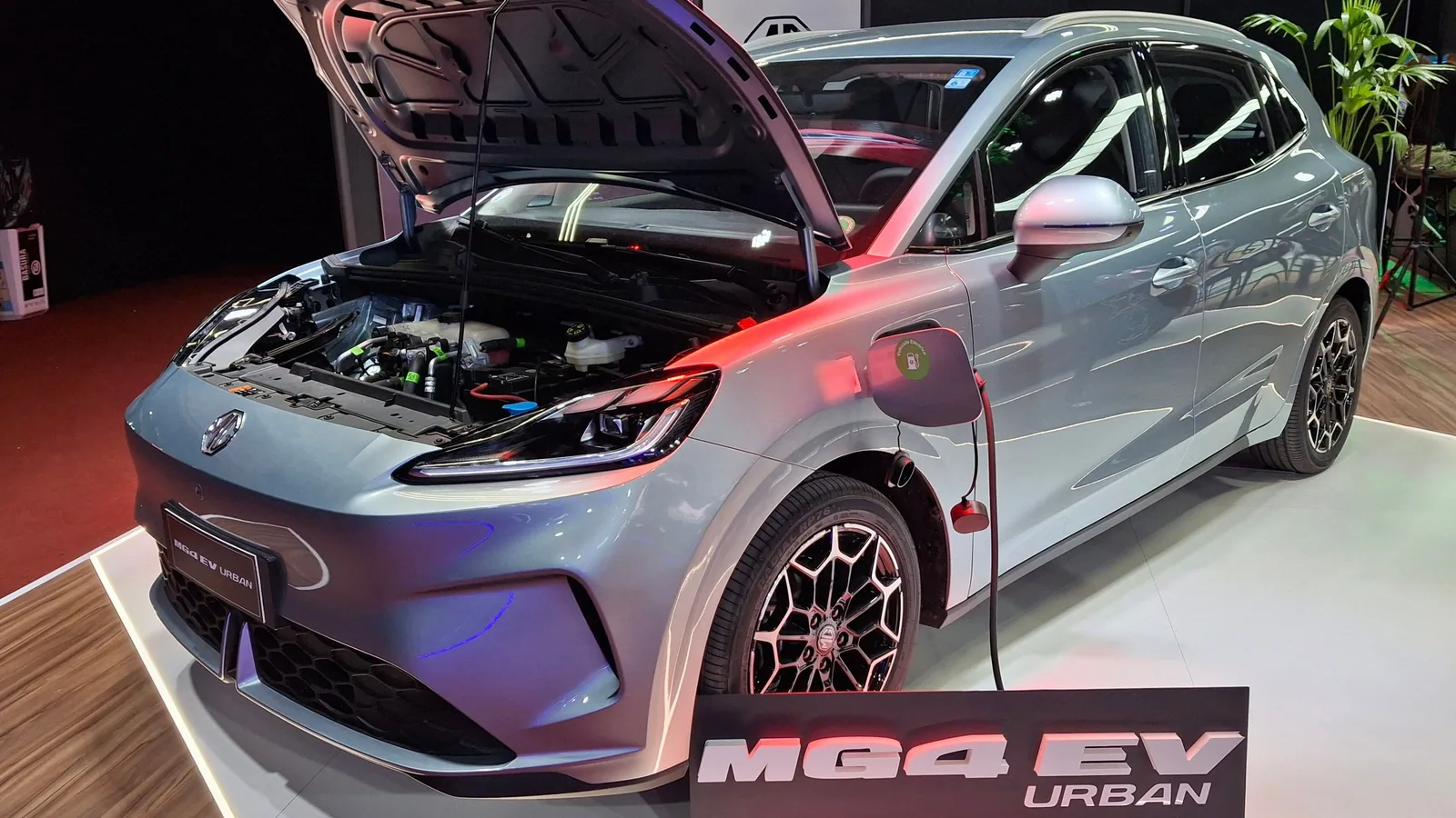 MG4 Urban électrique gris clair exposée, capot ouvert et câble de recharge branché