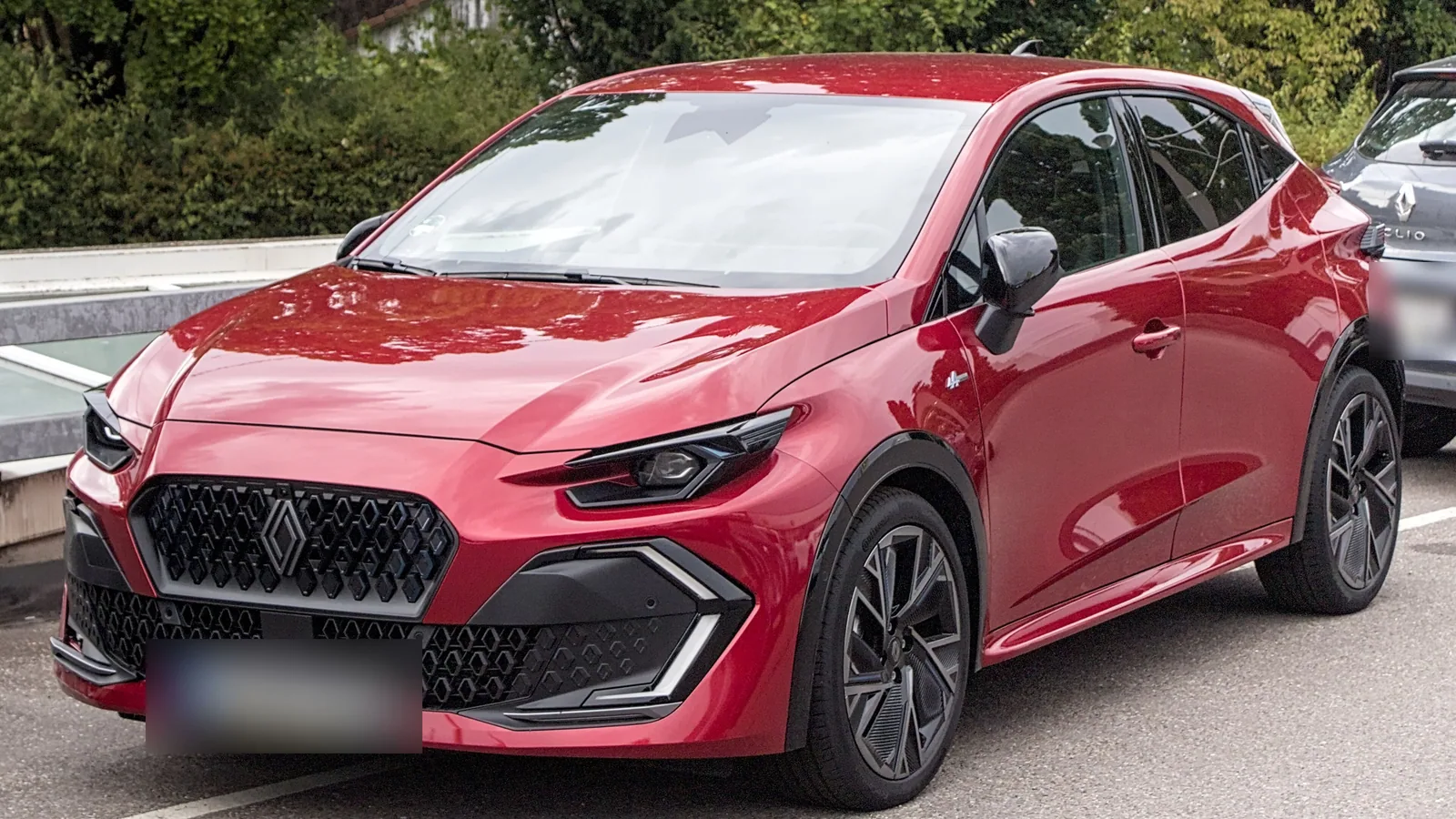 Renault Clio de sixième génération rouge garée, vue de trois quarts avant