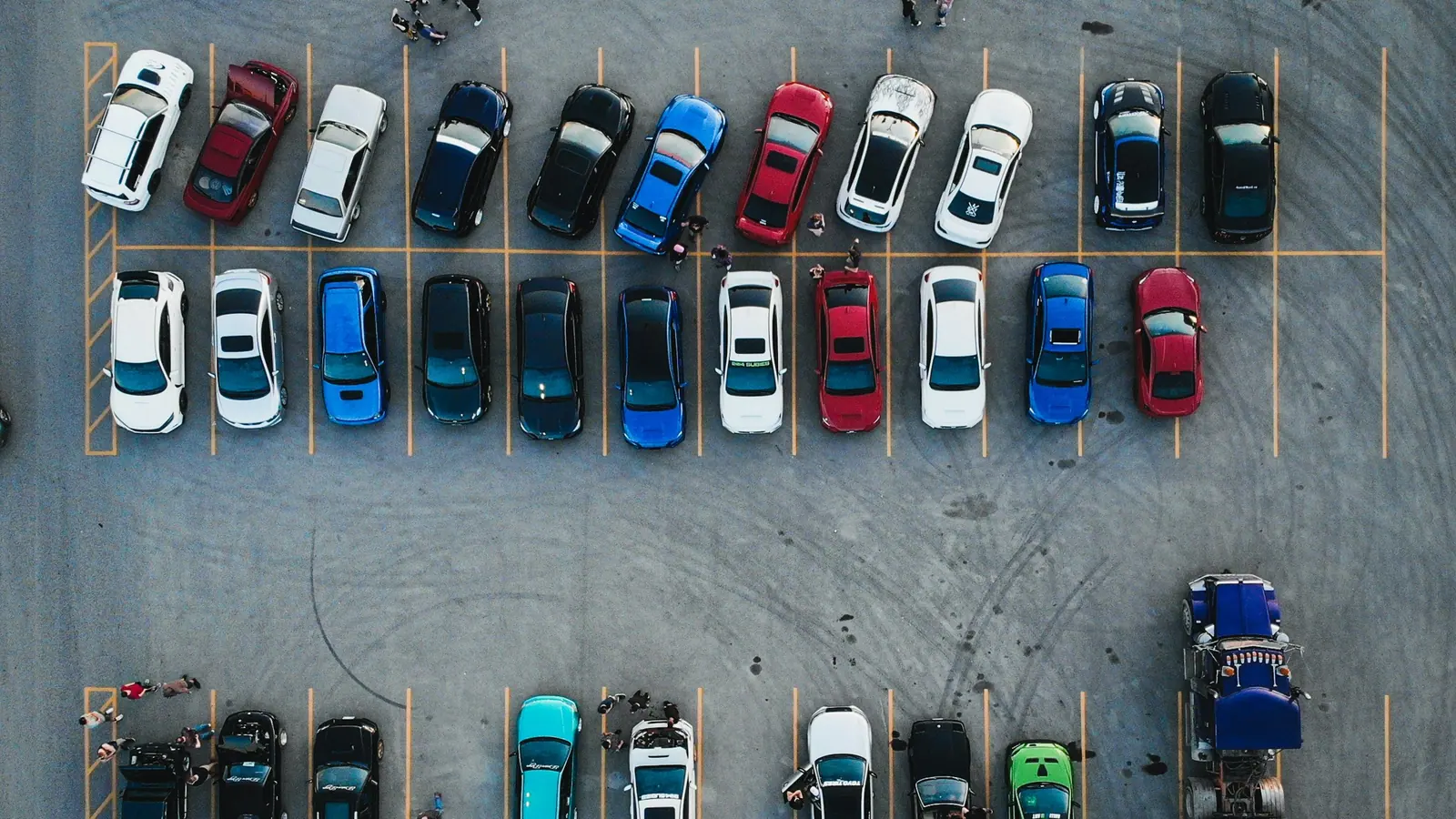 Vue aérienne d’un parking où des voitures de toutes couleurs sont garées en rangées