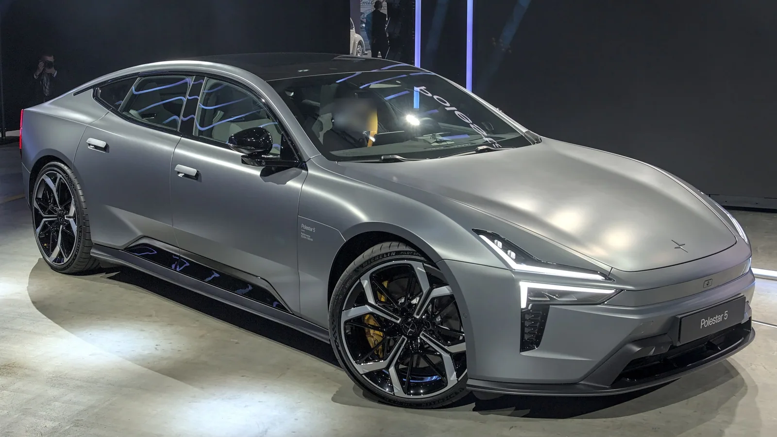 Polestar 5 grise exposée au salon Auto Zürich 2025, vue de trois quarts avant