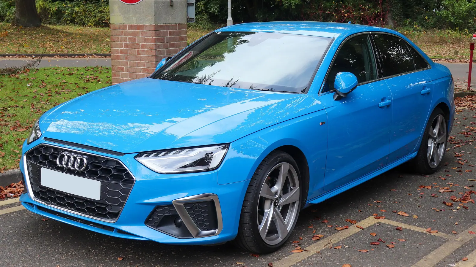 Audi A4 berline bleue restylée, vue de trois quarts avant sur un parking