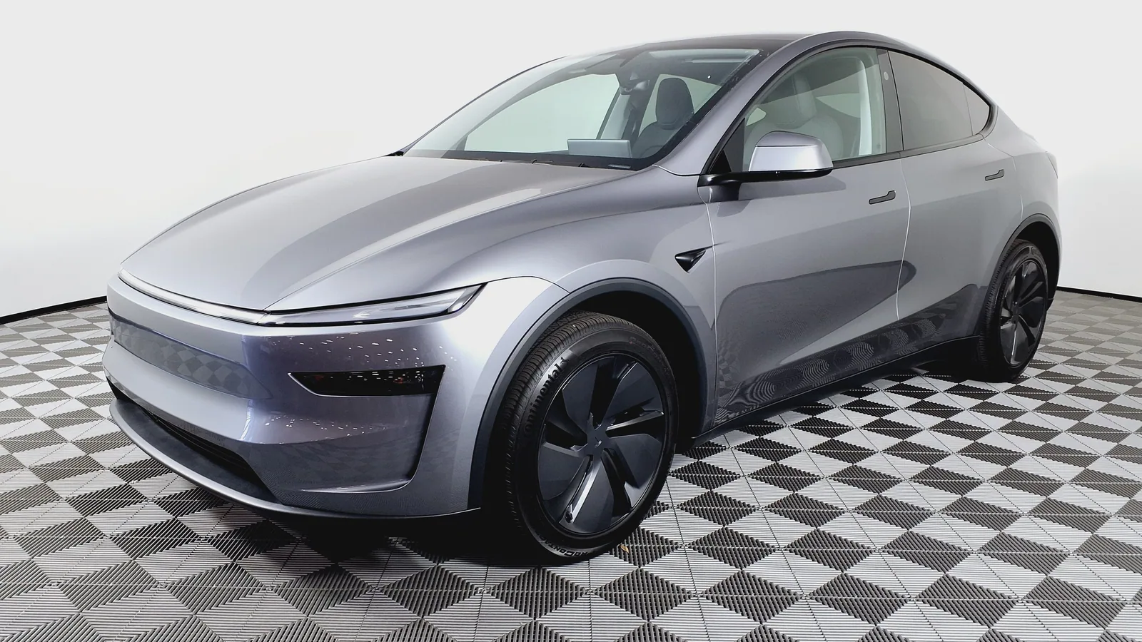 Tesla Model Y restylée gris argent exposée sur un sol en damier