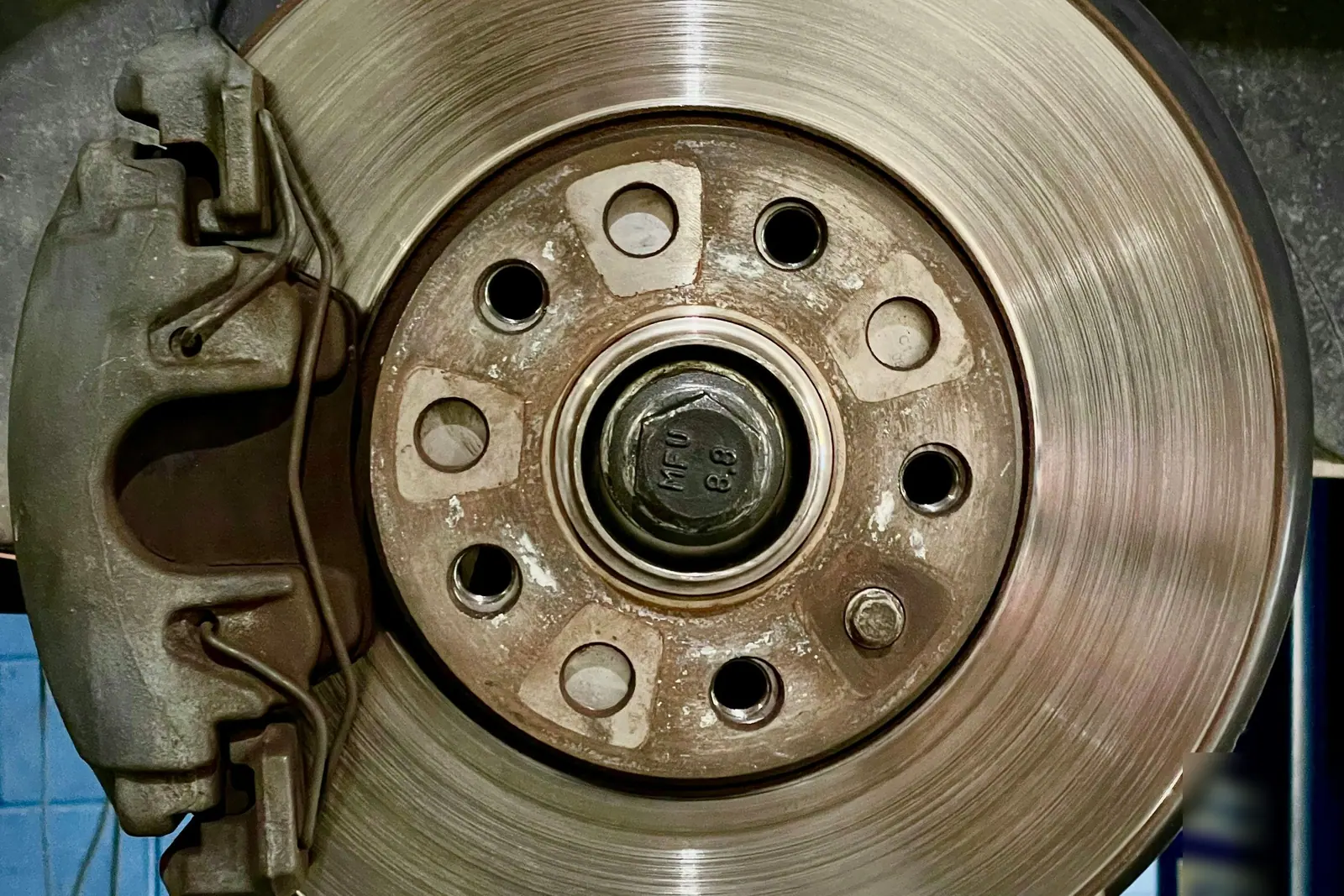 Gros plan sur un disque de frein marqué de rouille et son étrier