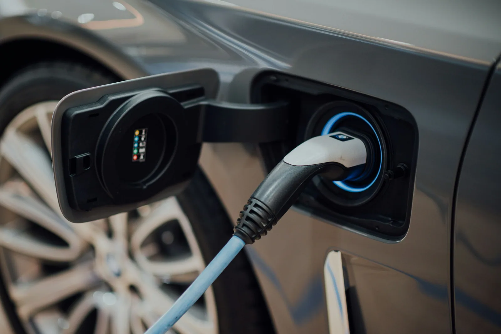 Câble de recharge branché dans la prise d’une voiture électrique grise