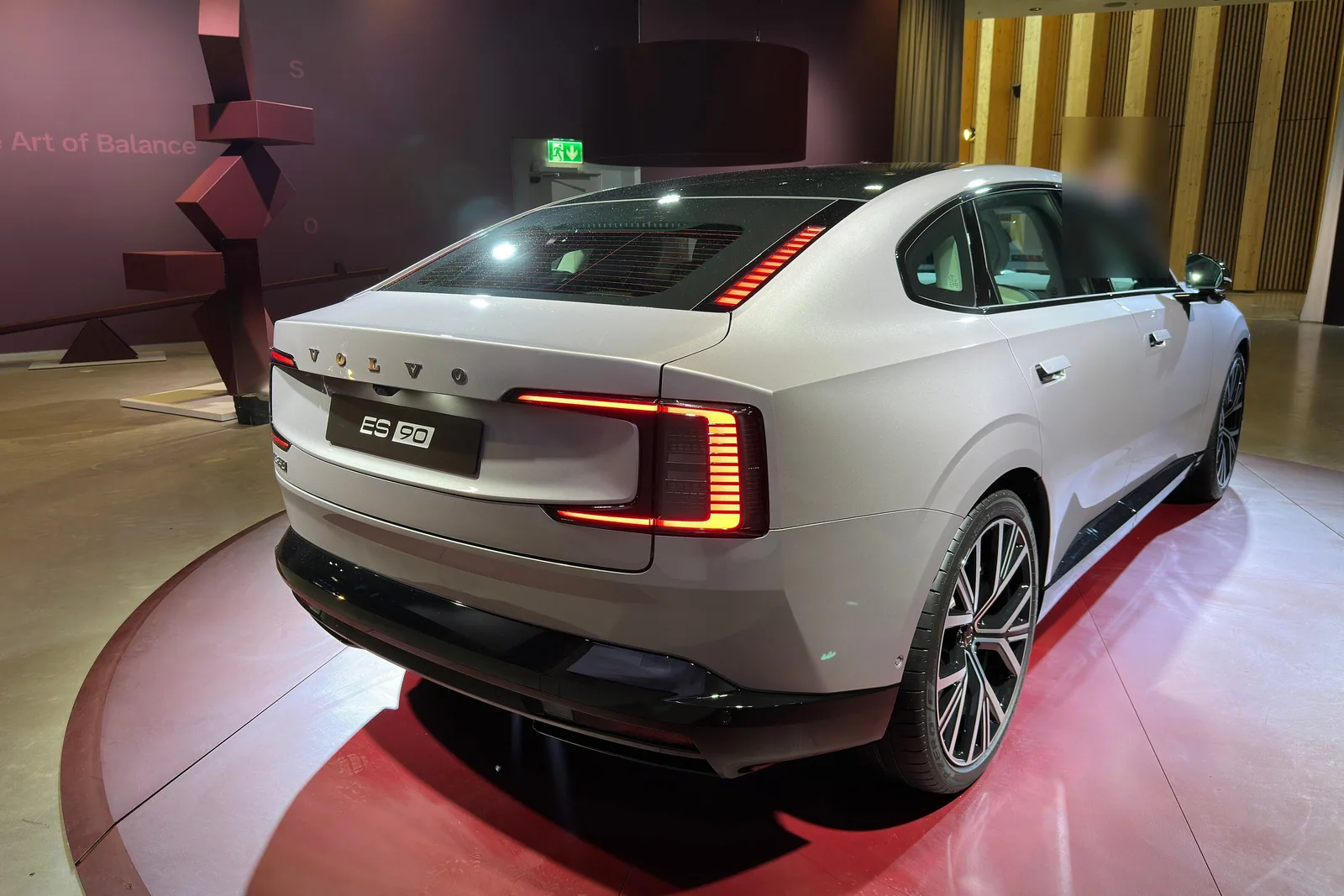 Volvo ES90 grise vue de l’arrière dans un hall d’exposition