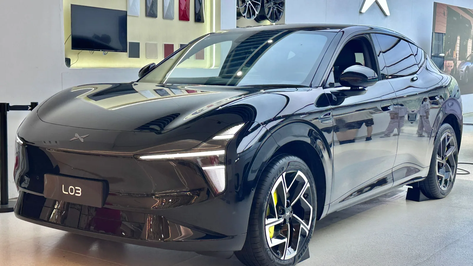 Xpeng L03 gris foncé exposé dans un showroom, vue de trois quarts avant